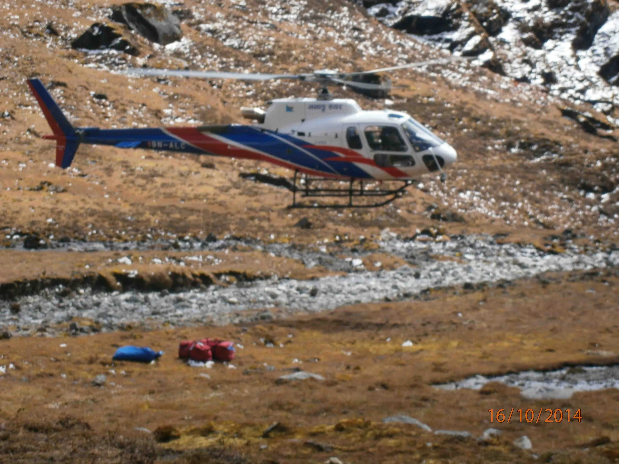 a helicopter coming into land on rocky ground