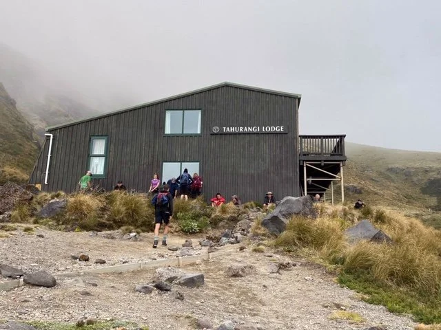 hikers have a rest outside Tahurangi Lodge