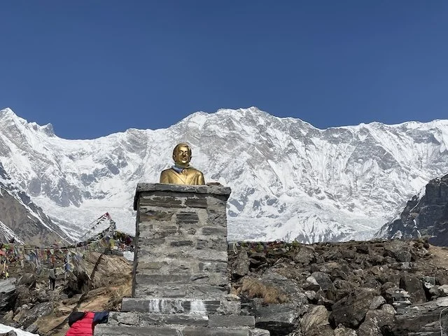 A statue of Maurice Herzog in front of Annapurna