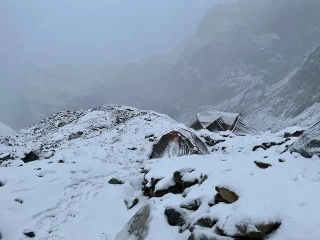 tents covered in snow on glacier