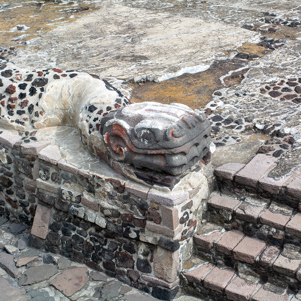 Close-up of ancient stone and brick step with a carved stone dragon head at the corner, part of a historical structure.