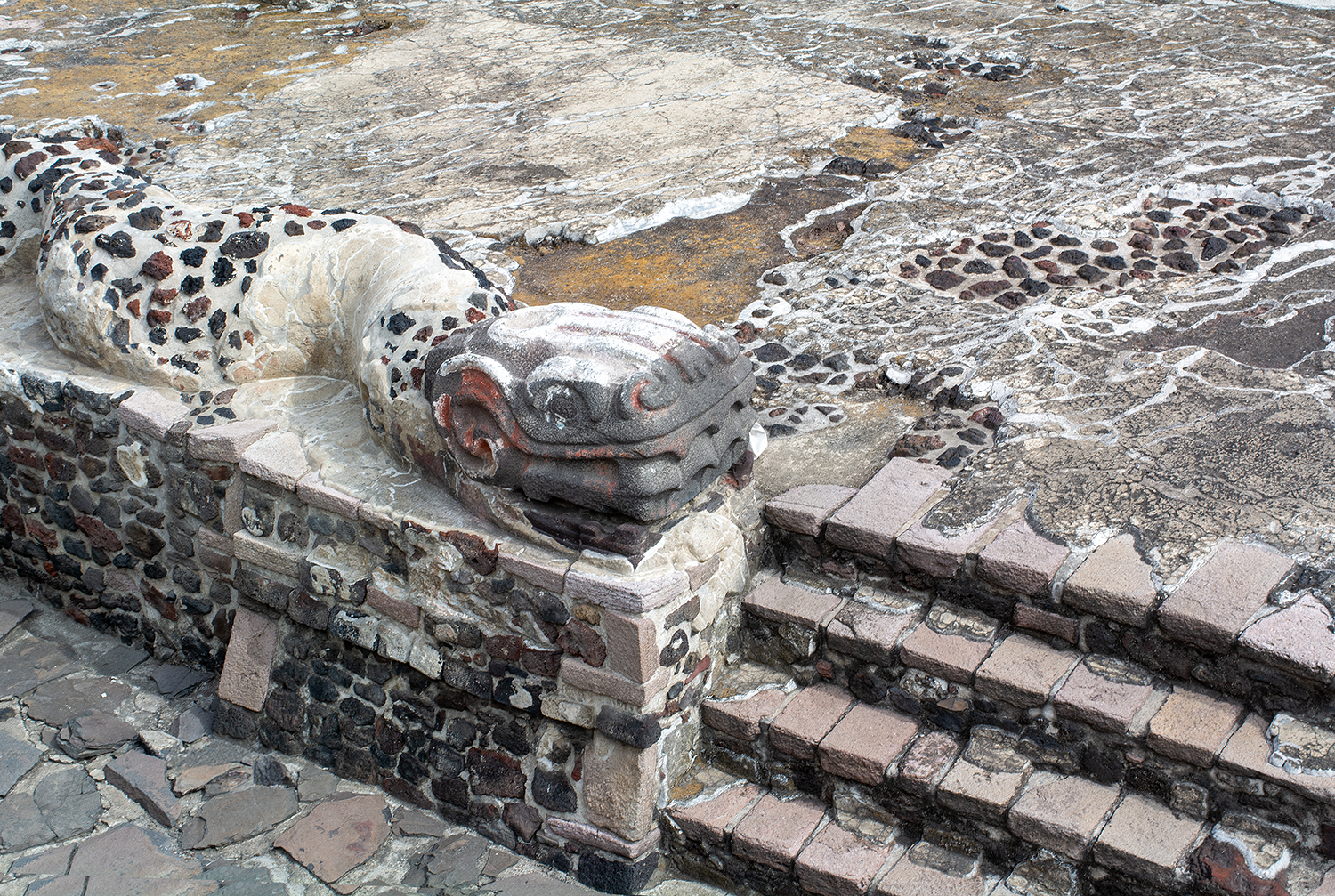 Ancient stone steps with a decorative stone dragon head at the corner of the stairs, part of a historical or archaeological site.
