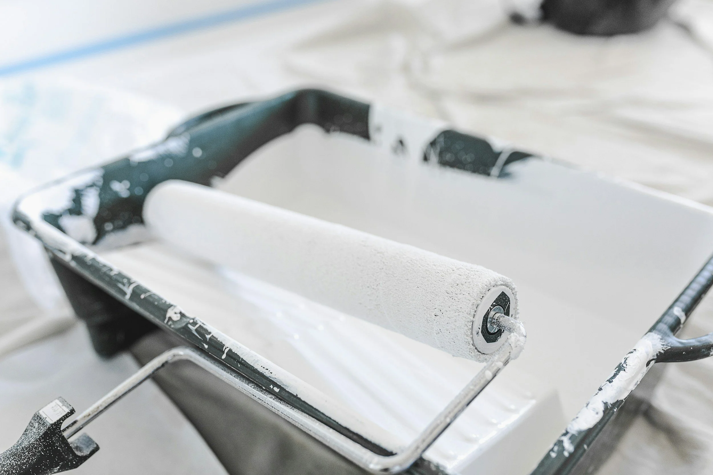 A snow-covered metal sled with a white cylindrical foam pad on it.