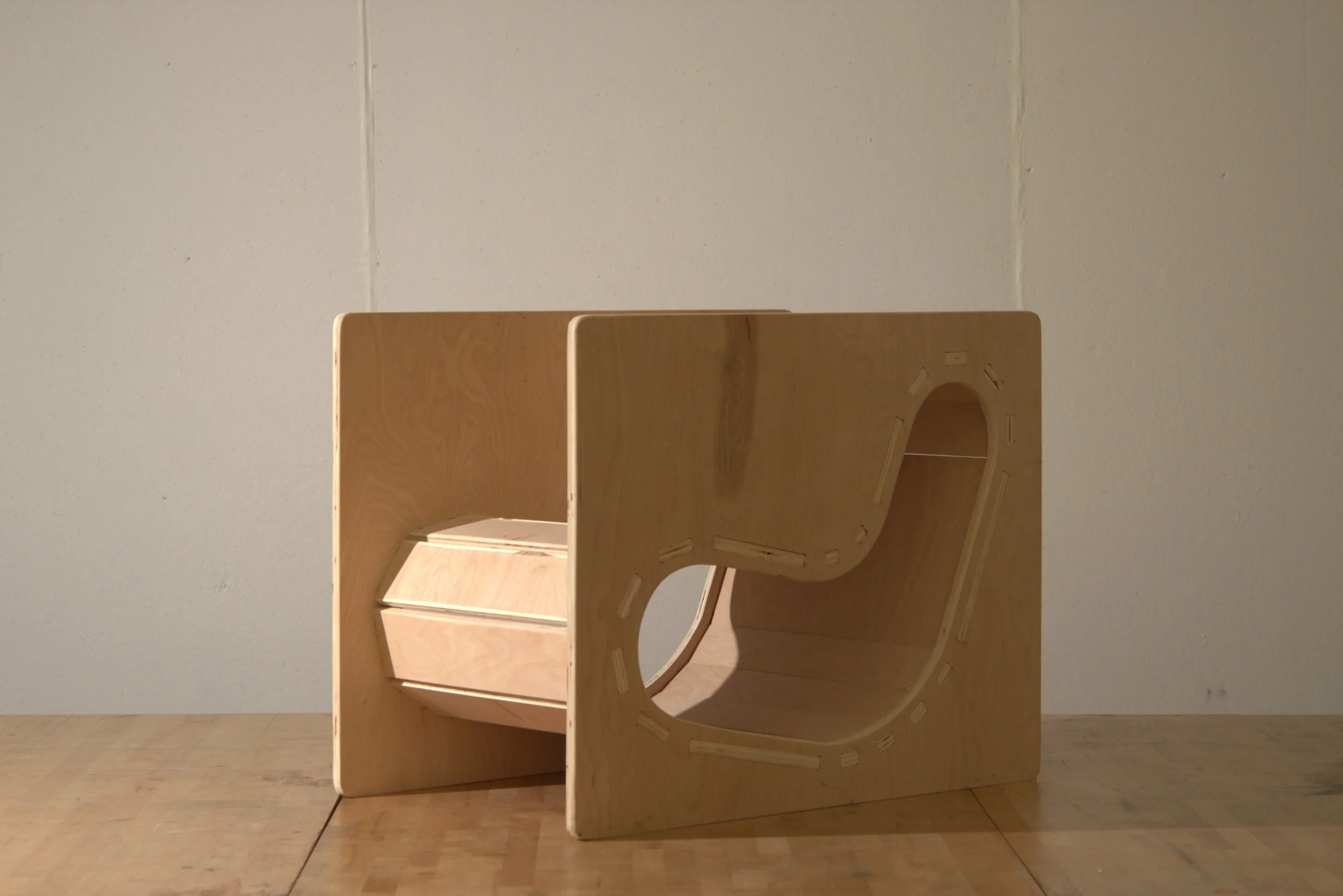 Wooden shelving unit with multiple open compartments, standing on a light wood floor against a white wall.
