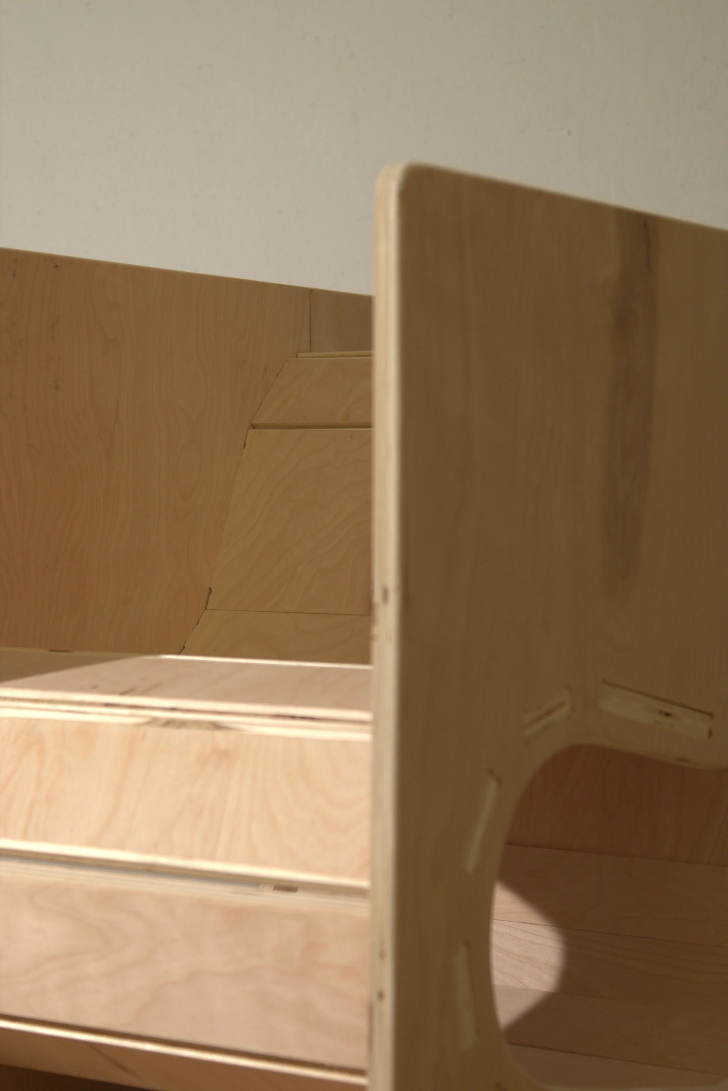 Close-up view of a wooden desk organizer with multiple compartments, made of light-colored wood.