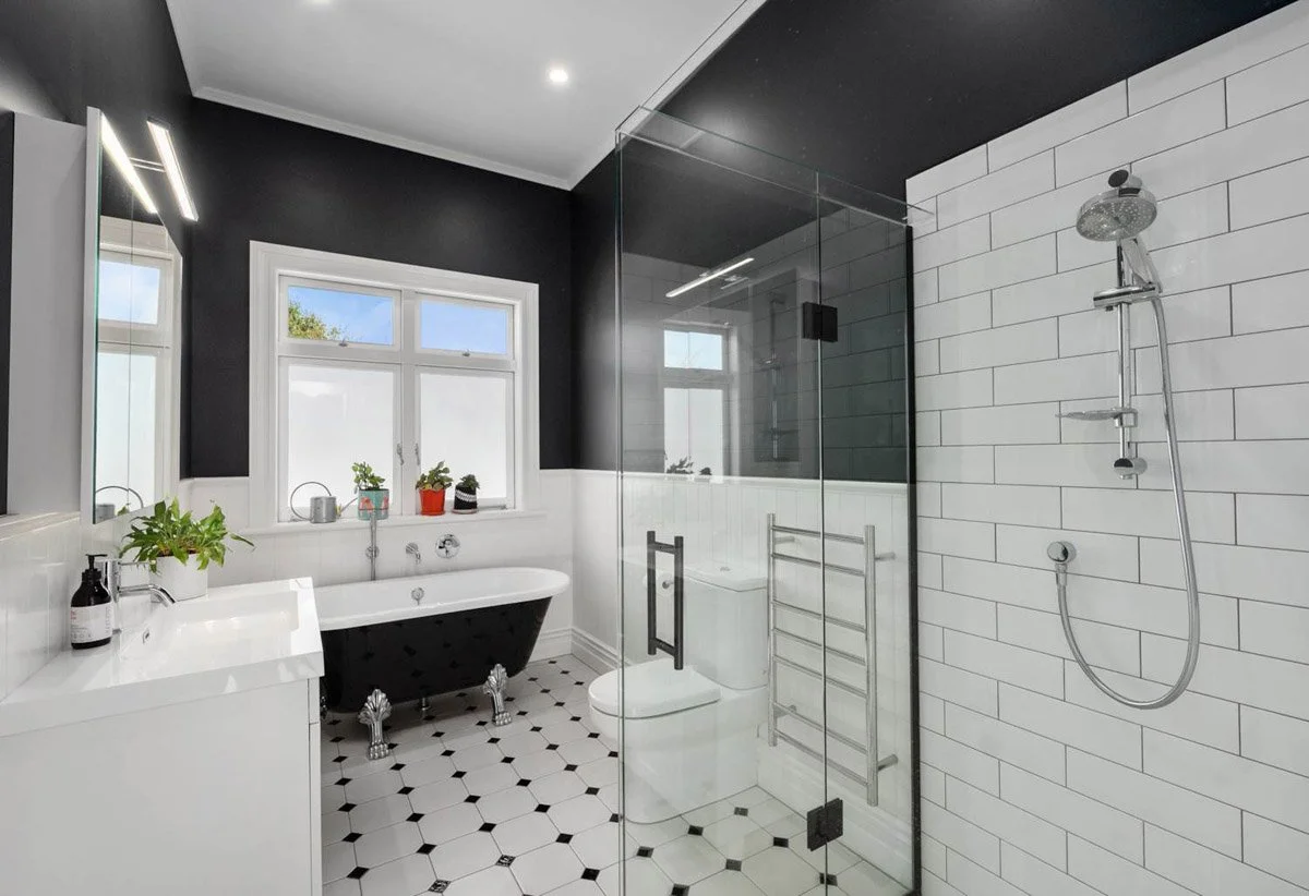Character-inspired bathroom renovation featuring freestanding bath, tiled shower and period detailing in Devonport home.
