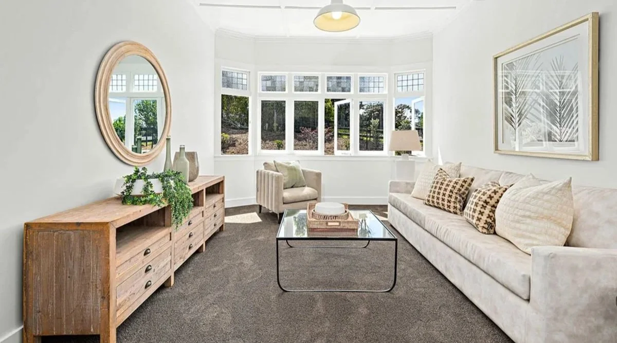 Character lounge in restored Tawharanui country villa featuring original timber windows, high ceilings and soft neutral interiors.