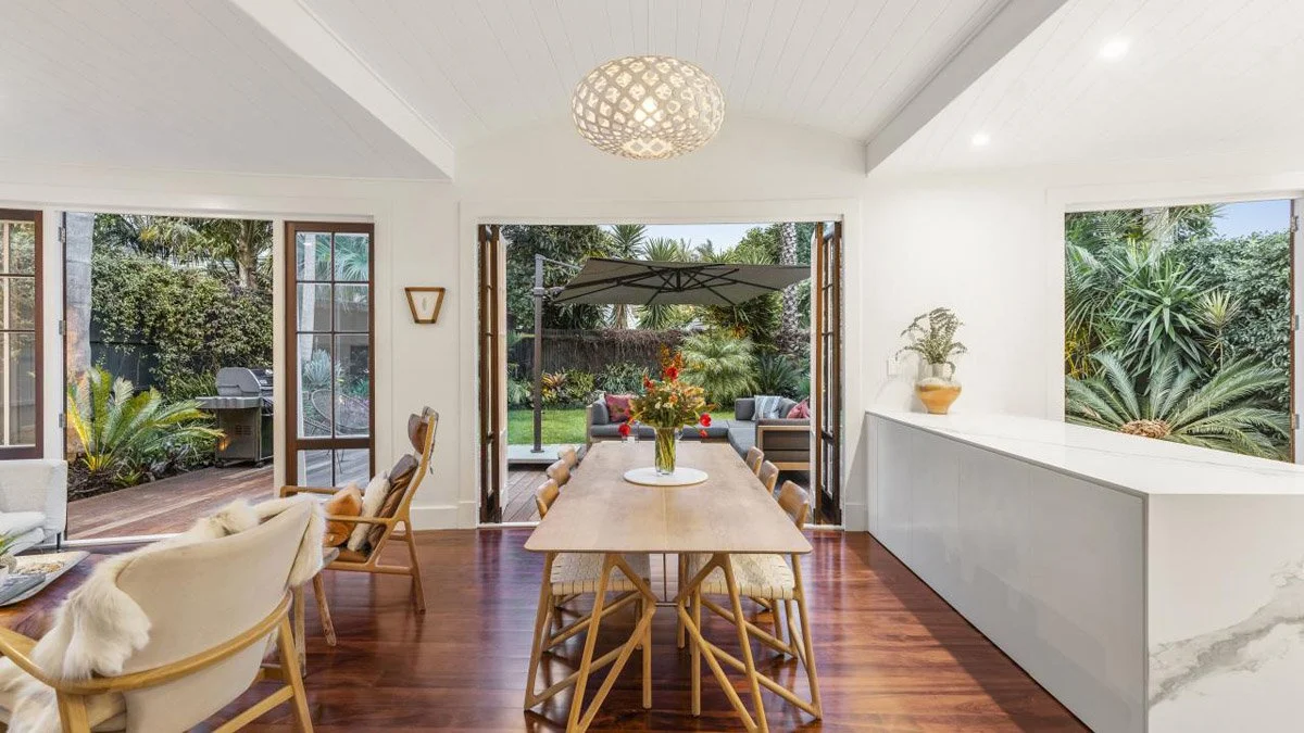 Open-plan dining and living area connecting to outdoor entertaining space at Devonport renovation