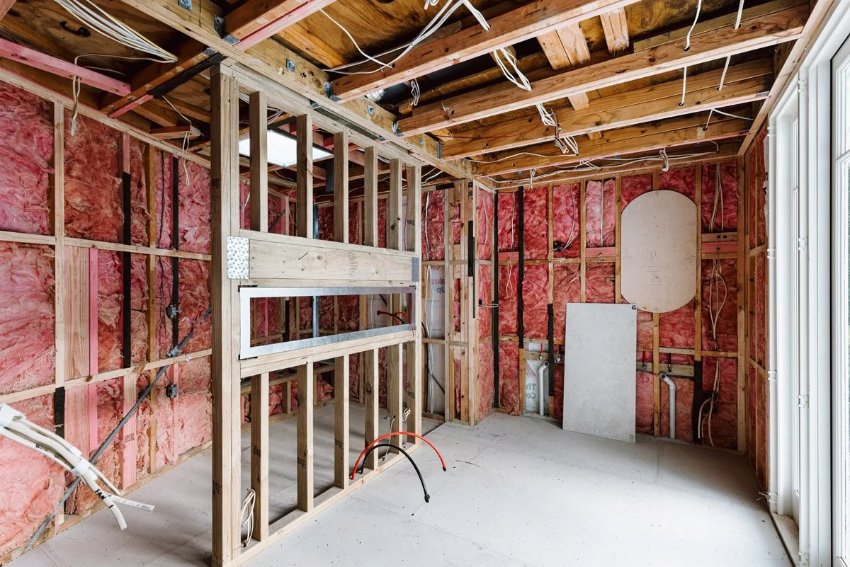 Bathroom renovation at framing stage with exposed timber structure, insulation and services installation in an Auckland luxury home renovation.