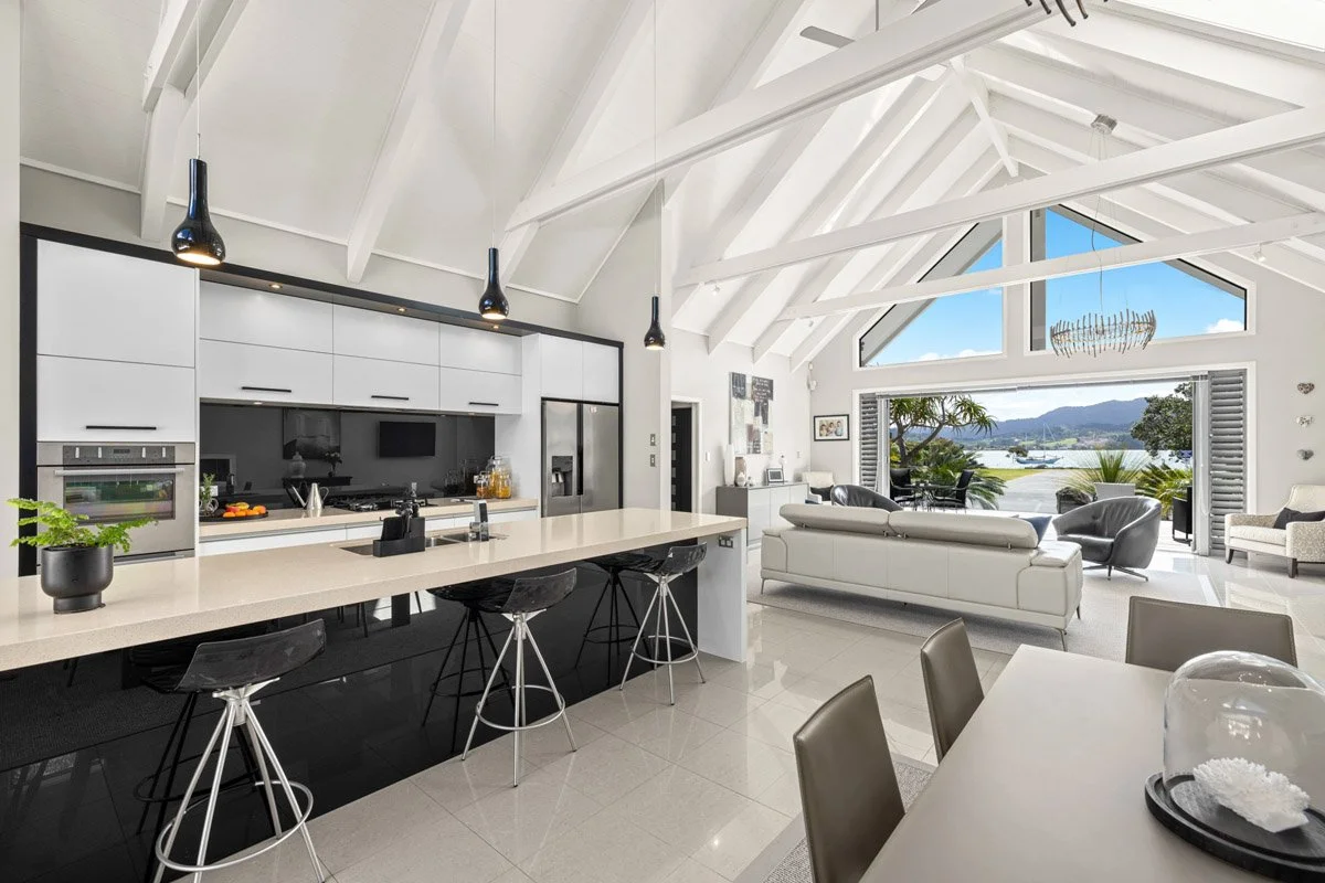 Modern kitchen with oversized island and open-plan living spaces in an architectural Omaha waterfront home.