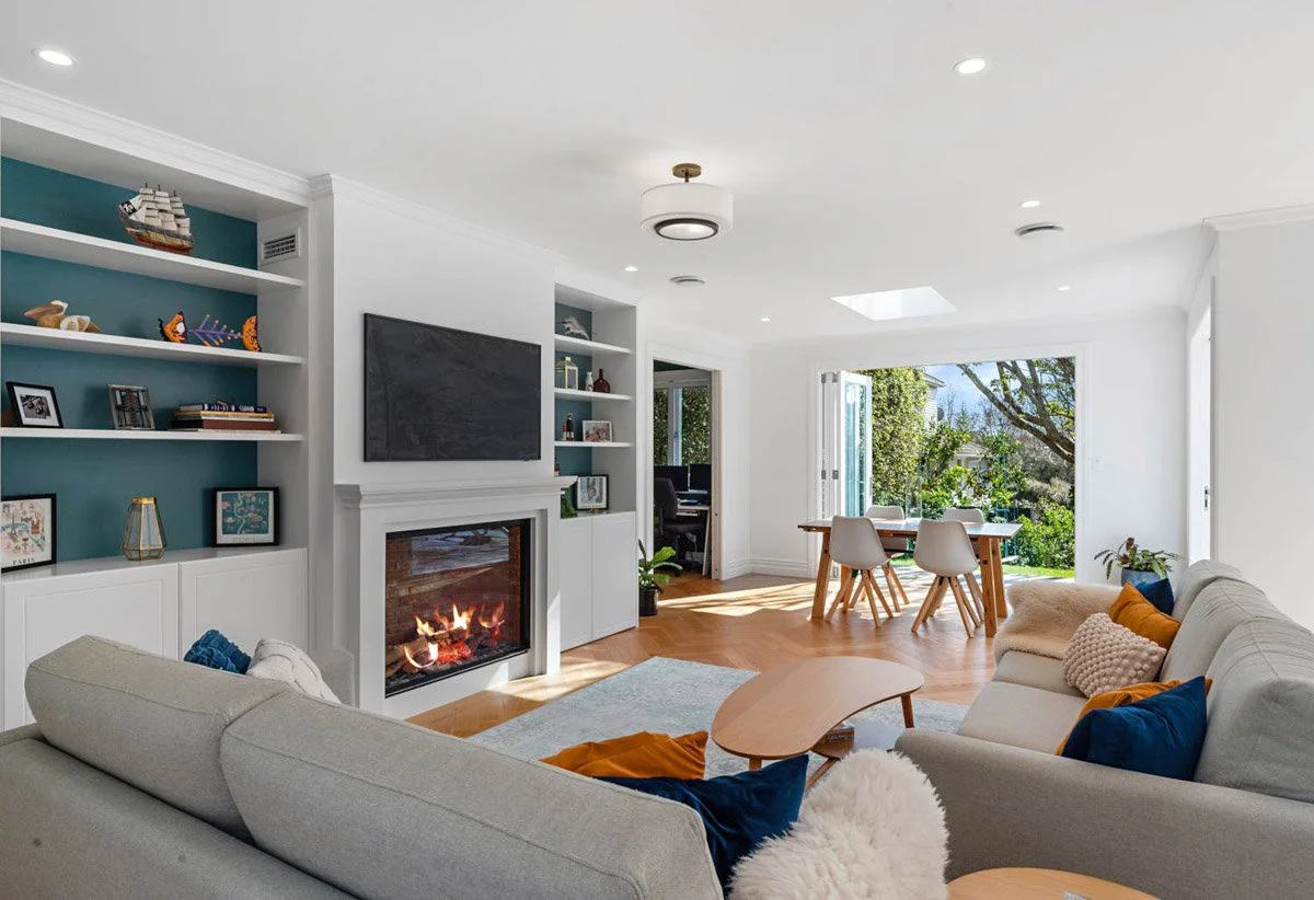 Renovated living room with built-in cabinetry, fireplace and garden connection in a restored Devonport villa.