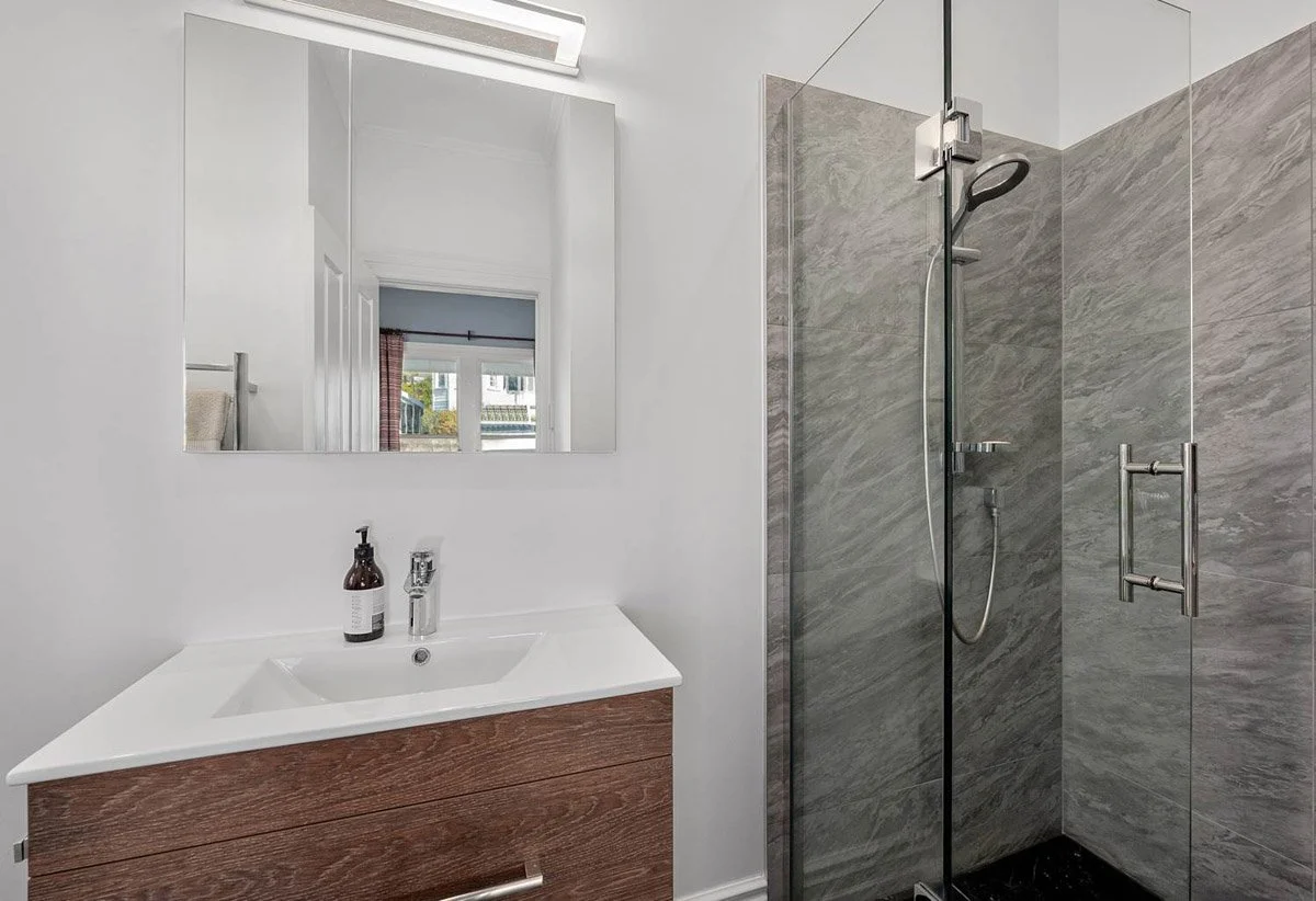 Contemporary ensuite bathroom with tiled shower and timber vanity in renovated Devonport home.