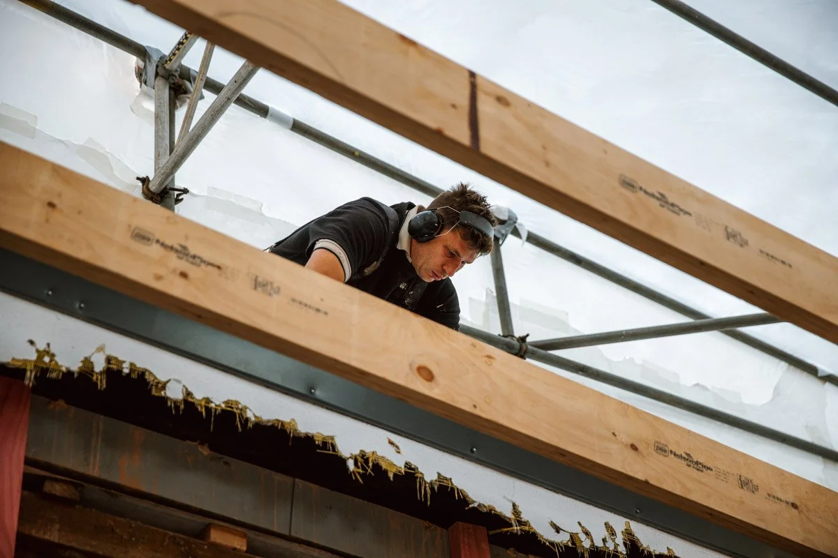 Builder working on structural restoration and roof framing during a heritage home renovation in Devonport.