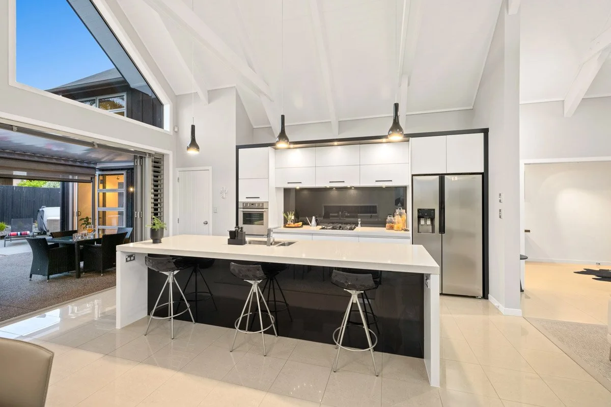 Open-plan kitchen and living space with vaulted ceilings and harbour views in an Omaha waterfront residence.