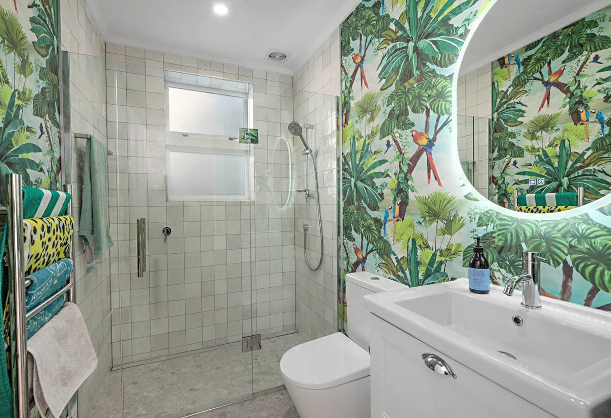 Modern family bathroom renovation with walk-in shower, feature tropical wallpaper and contemporary fittings in Devonport home.