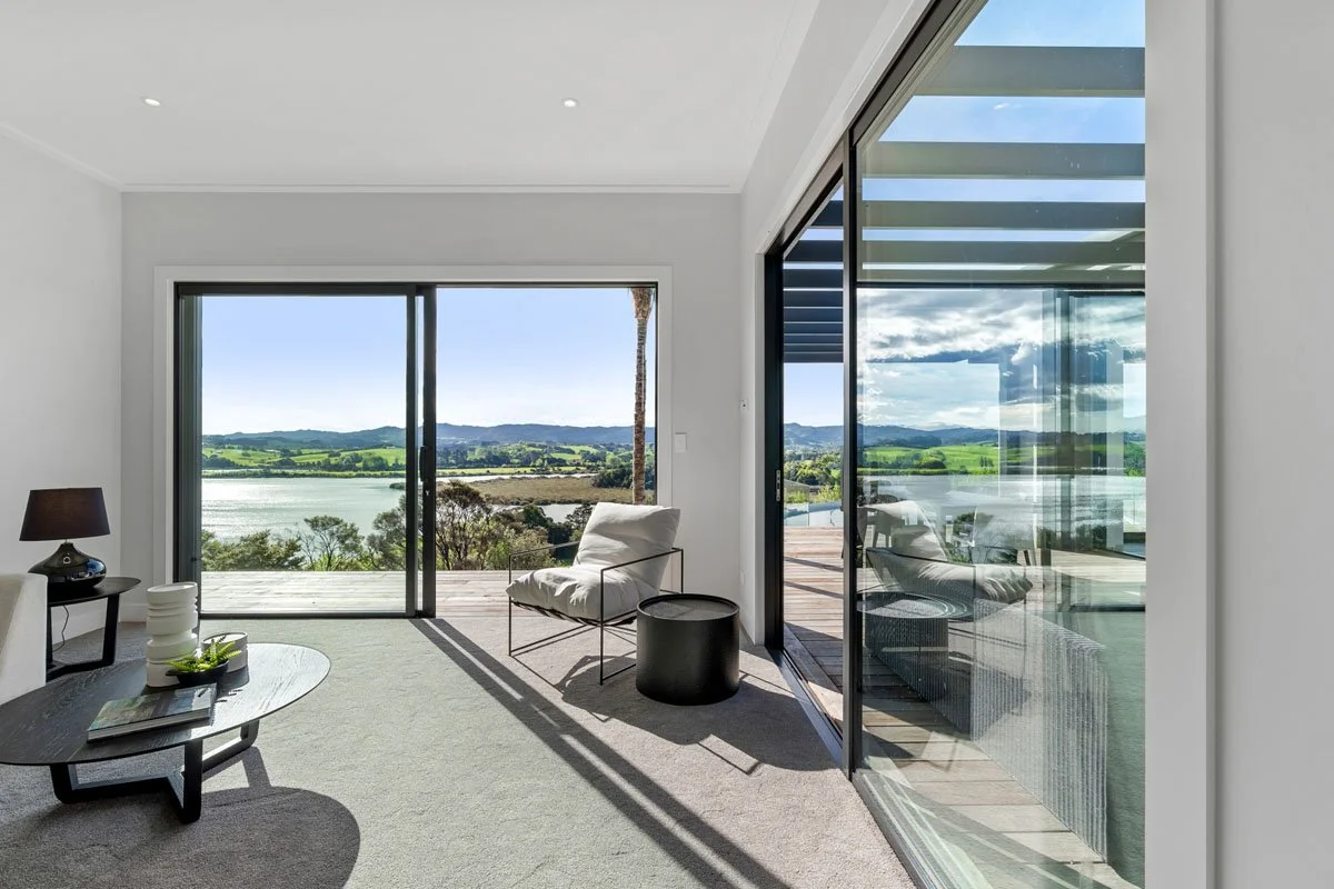 Master bedroom with expansive rural and water views at Matakana country home