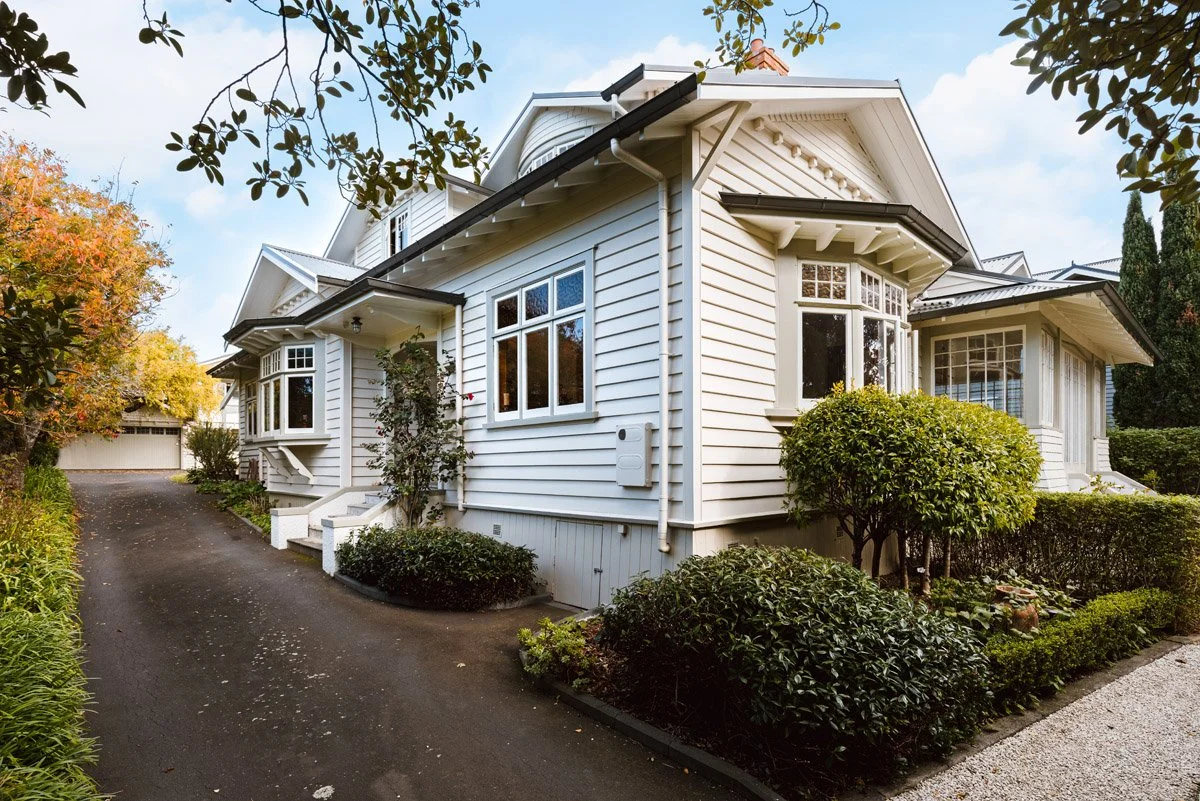 Side elevation of renovated character home showcasing restored weatherboards and mature landscaping.