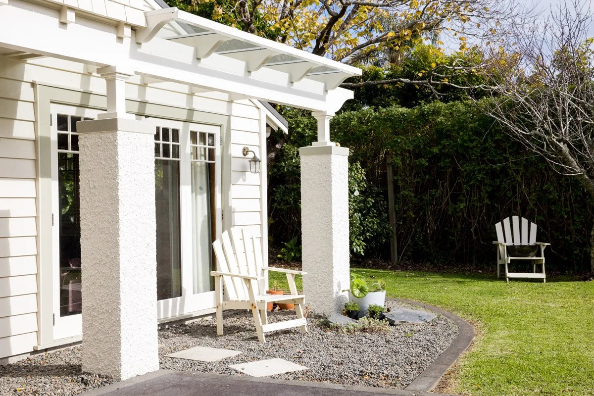 Covered outdoor seating area and landscaped garden connected to a renovated Auckland character home.