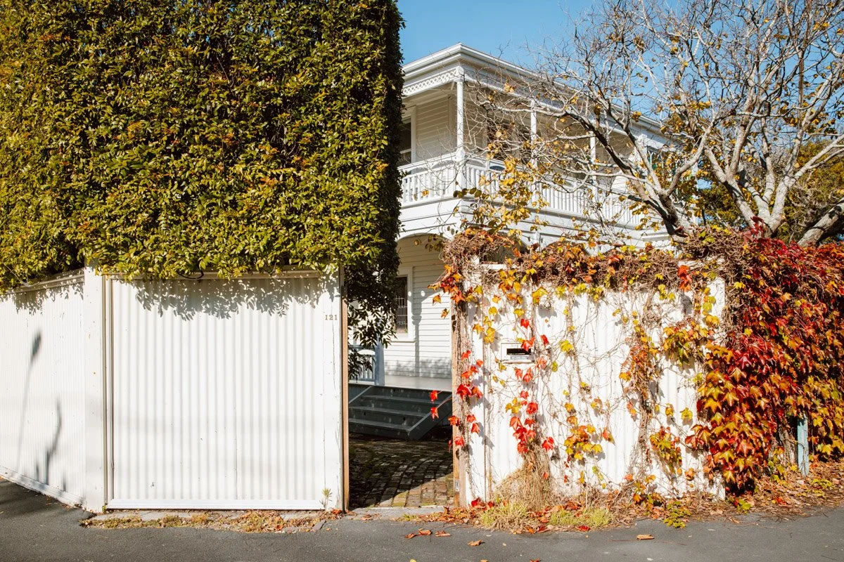 Street view of a restored character home in Narrow Neck, Auckland, featuring heritage architecture, mature landscaping and traditional detailing.