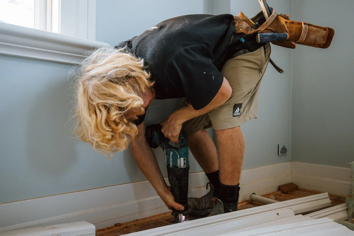 Builder carrying out detailed carpentry work during a luxury home renovation project by Coast & Country Homes in Auckland.