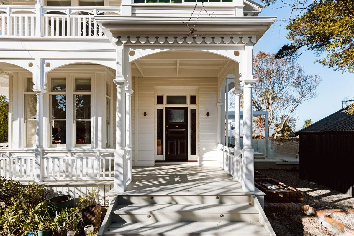 Front entrance of a restored heritage home in Narrow Neck, Auckland, showcasing traditional timber detailing and architectural craftsmanship.