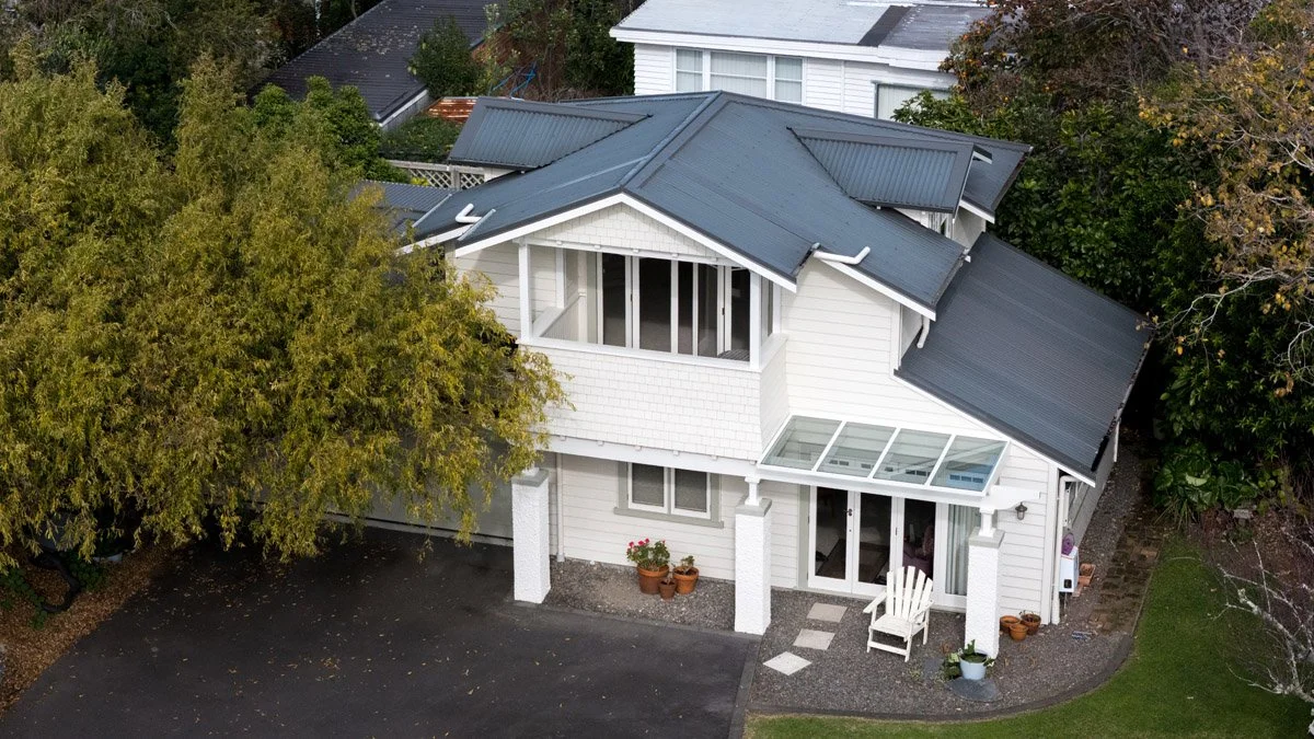Aerial perspective of a renovated character home featuring an integrated garage addition and outdoor living spaces.