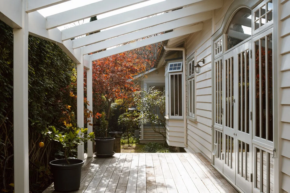 Covered verandah connecting indoor and outdoor living spaces within a renovated Auckland character home.