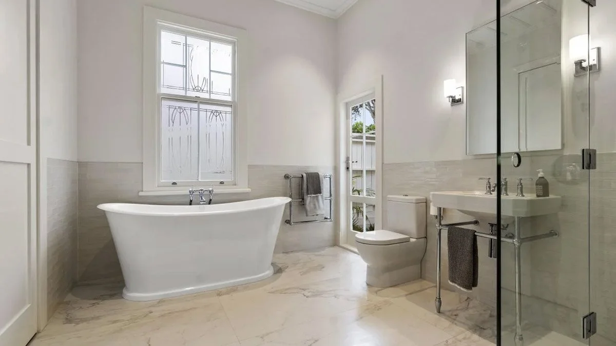 Renovated bathroom featuring freestanding bath, tiled flooring and heritage-inspired finishes