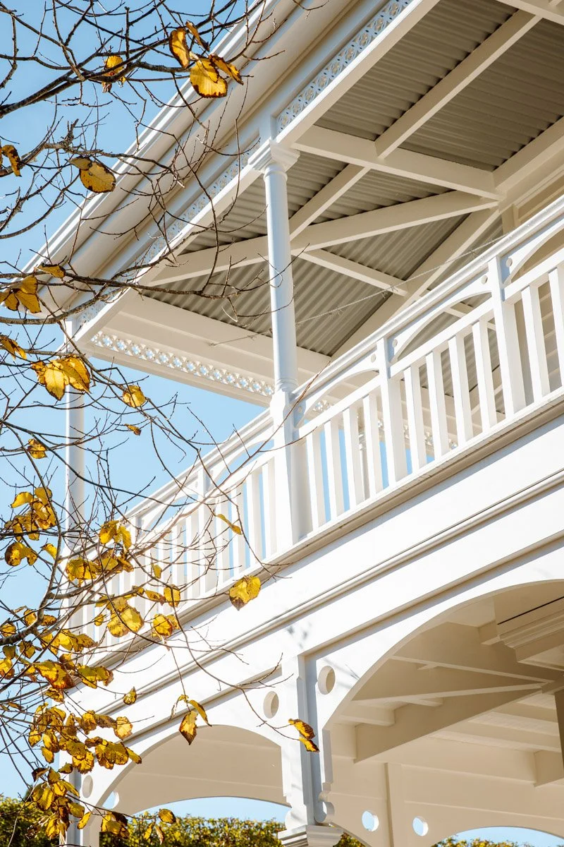 Heritage balcony and decorative fretwork on a restored character home in Narrow Neck, showcasing traditional villa architecture and craftsmanship.