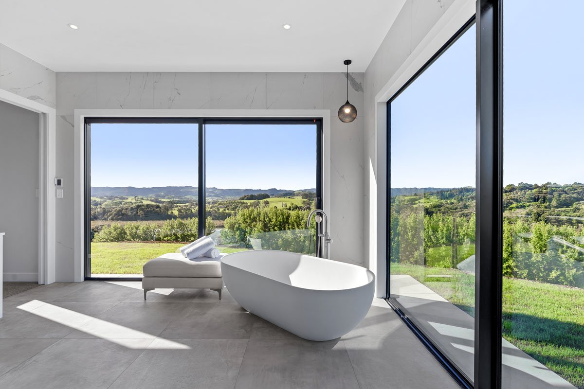 Architectural bathroom with tiled finishes in Matakana country home