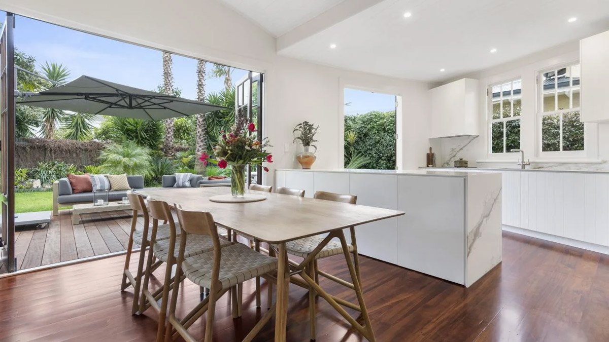 Open-plan kitchen and dining area opening directly onto outdoor living spaces
