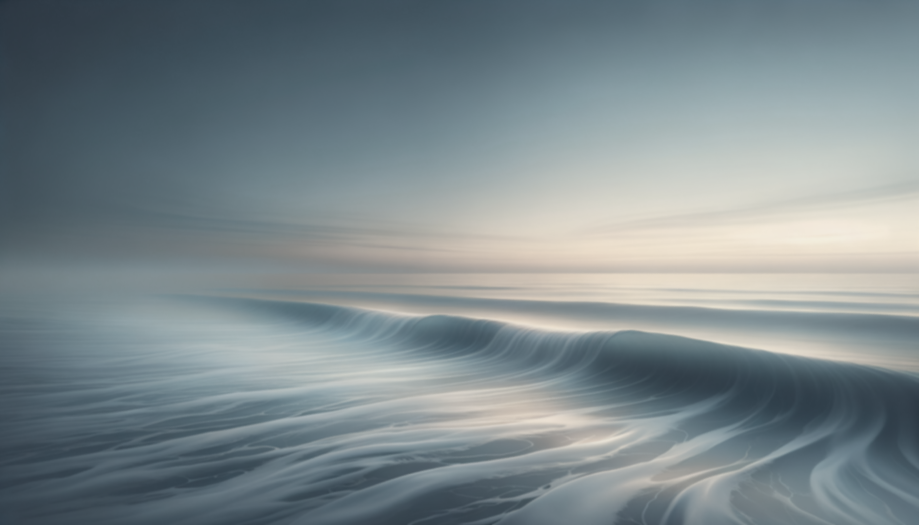 Blurred image of ocean waves with a calm, pastel-colored sky in the background