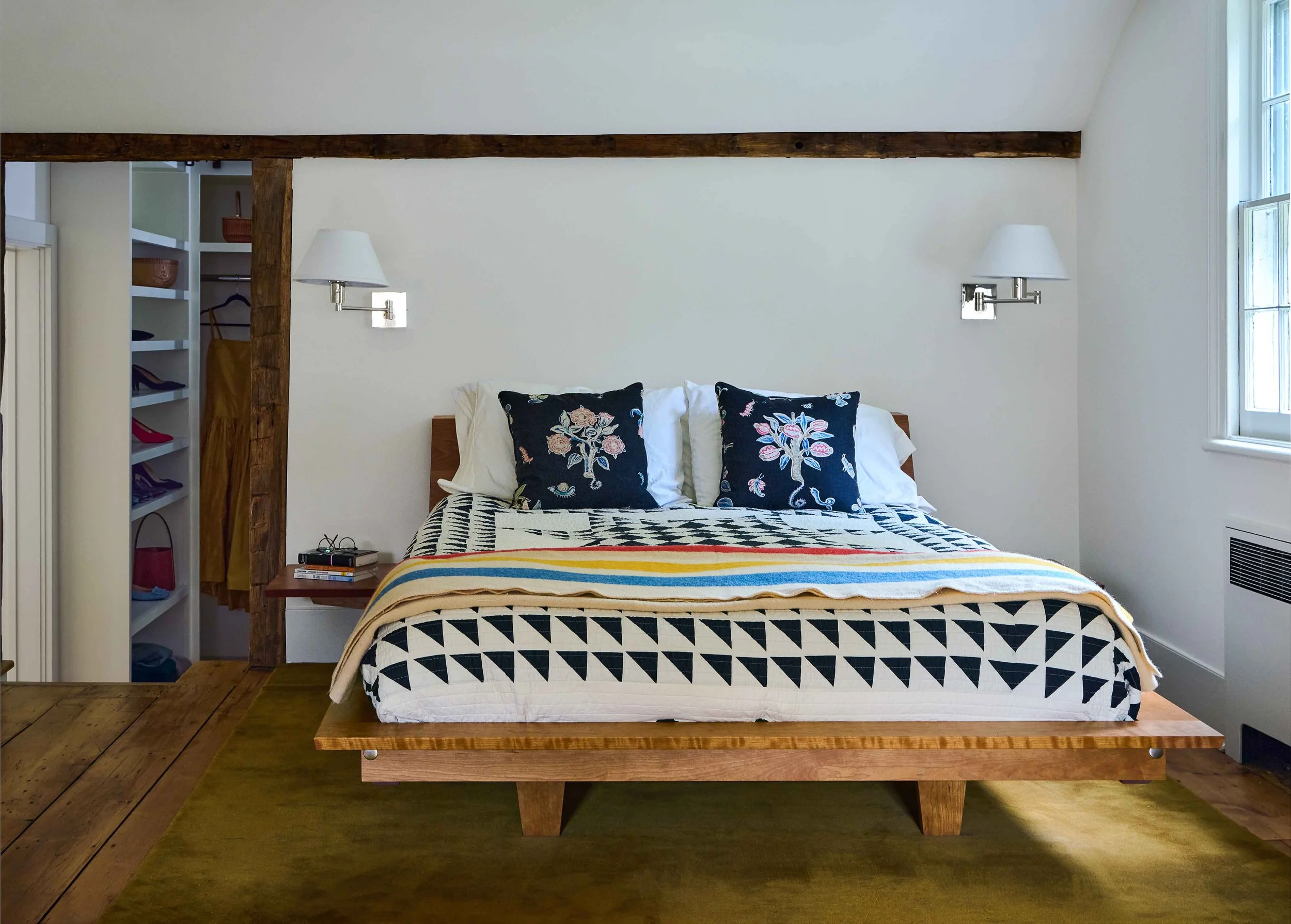 11-hobby-hill-farm-primary-bedroom-platform-bed-exposed-beam-olive-rug.jpg