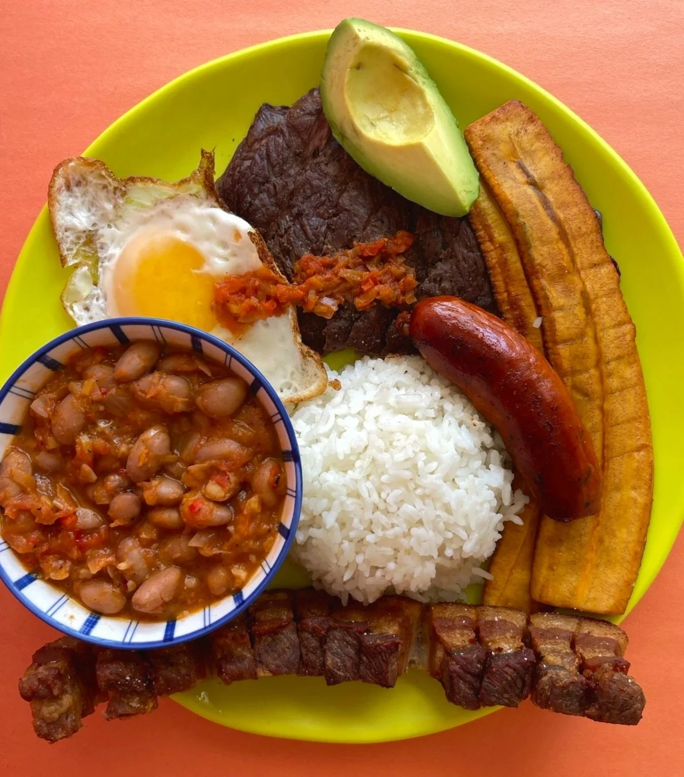 Typical Colombian dish bandeja paisa with plantain, eggs, avocado, ground beef, plantains and beans.