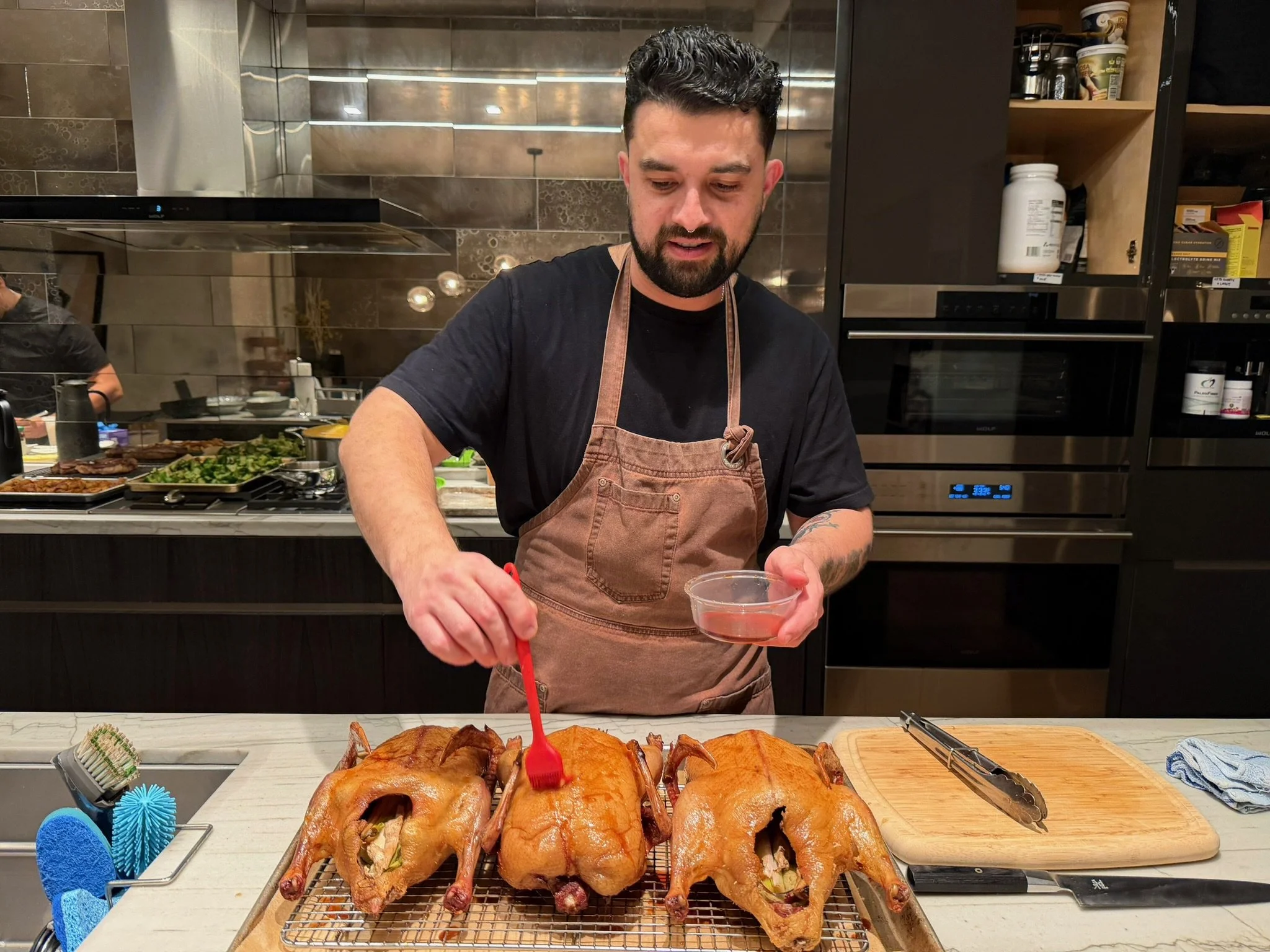 Chef cooking adding glaze to a turkey in a private kitchen for an event in San Francisco.