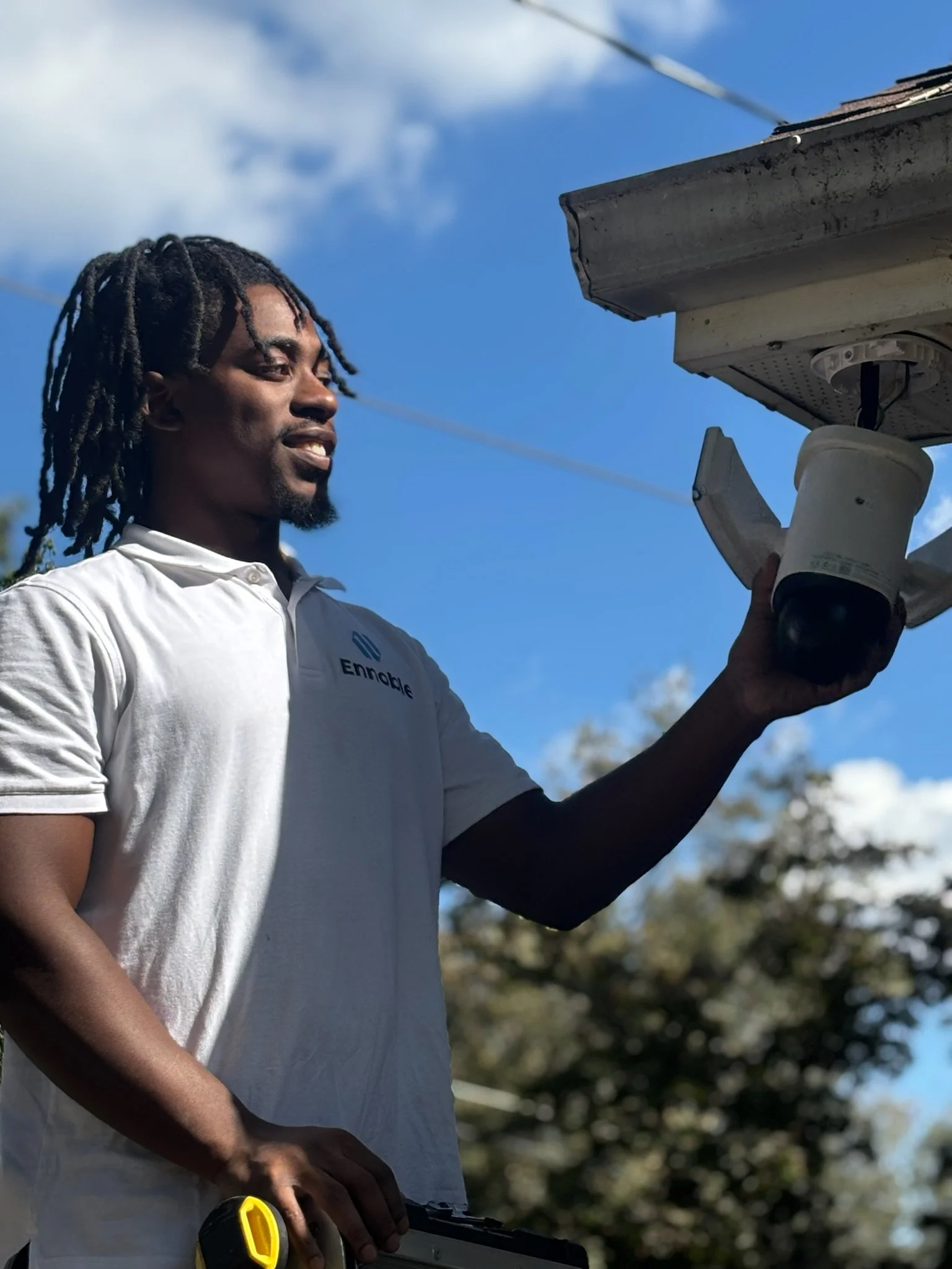 Security camera mounting on residential house by Ennoble Smart Home & Home Cinema  wearing uniform