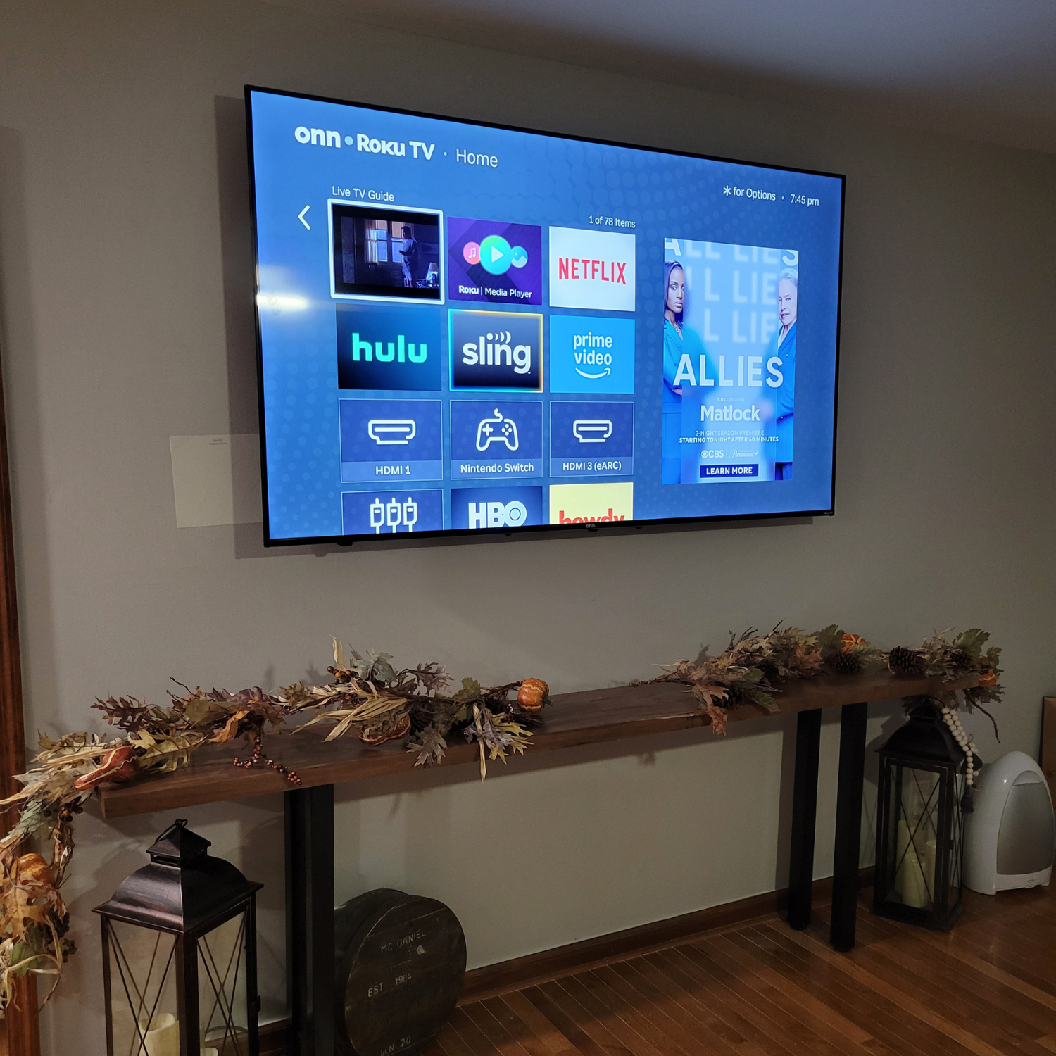 Professional large TV mounting installation over a modern wood console table by Ennoble Smart Home, featuring secure wall placement and a completely hidden wire finish in Murfreesboro TN.