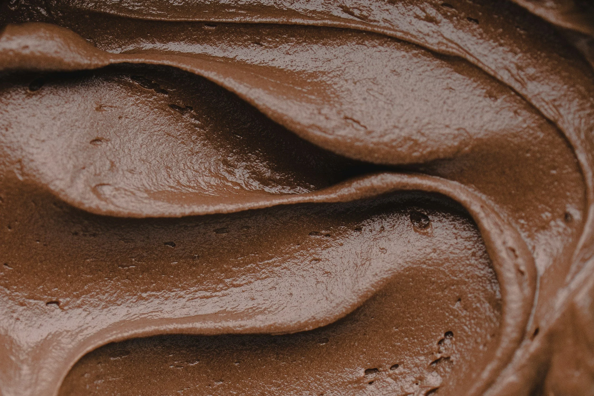 Close-up of smooth, swirled chocolate frosting.