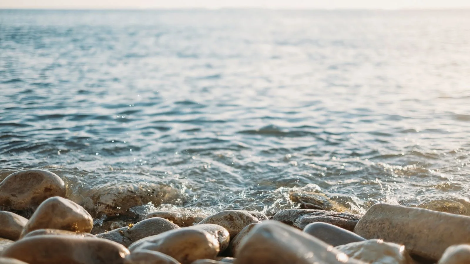 Close-up of rocks at the shoreline with gentle waves