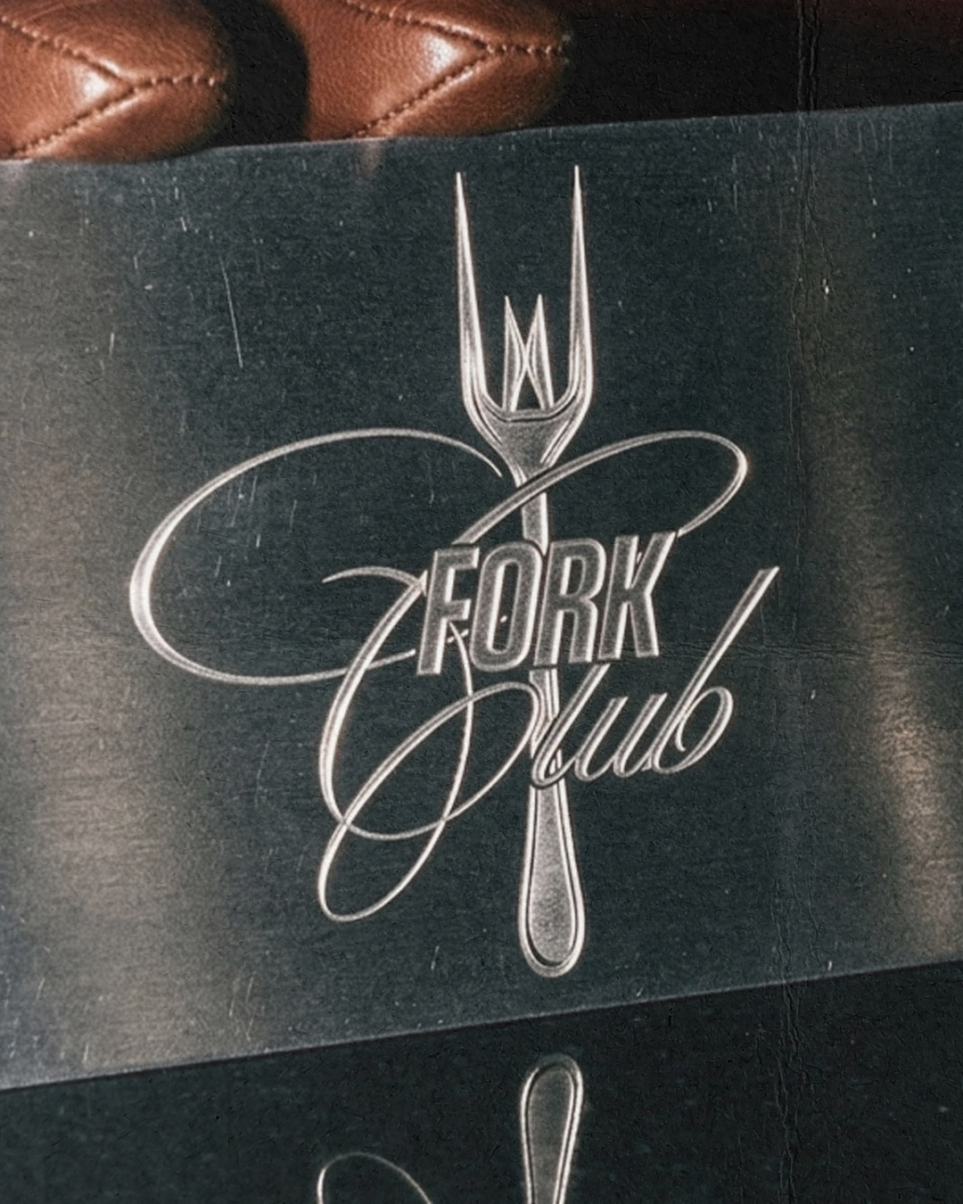 Close-up of a black card with a silver fork illustration and the words 'FORK Club' written in fancy script.