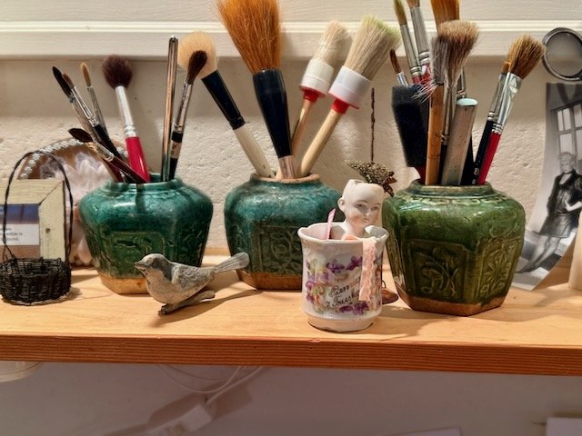 paint brushes doll head in jars