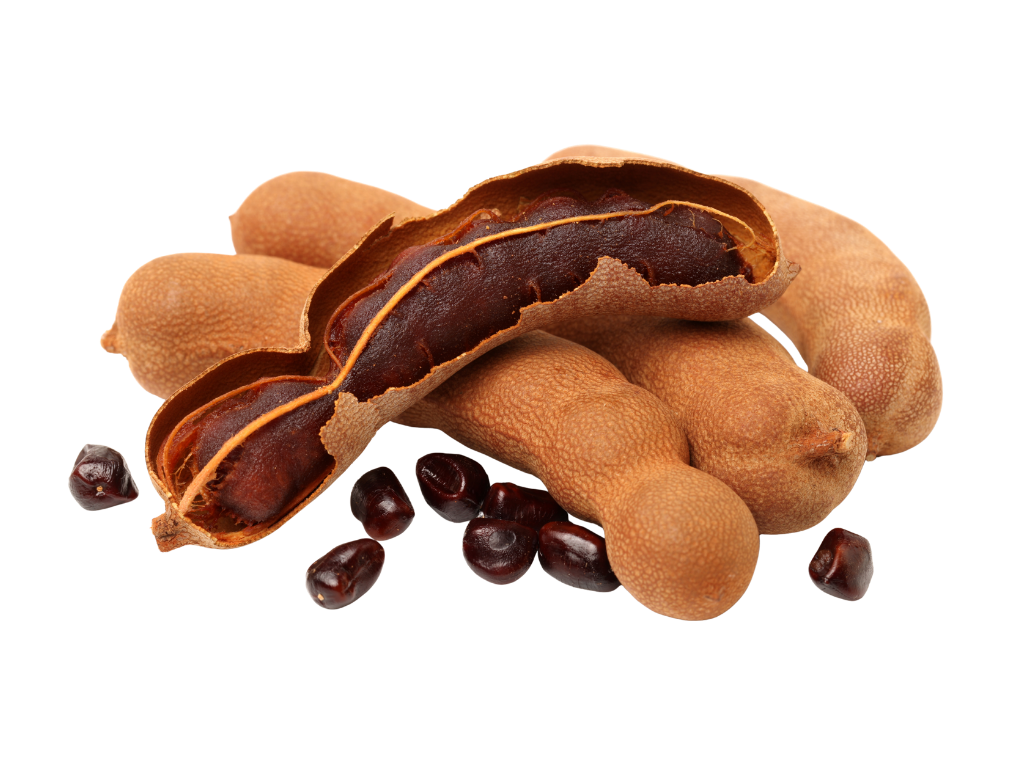 A group of tamarind pods with some open to reveal dark brown seeds and pulp inside, and some scattered tamarind seeds around.