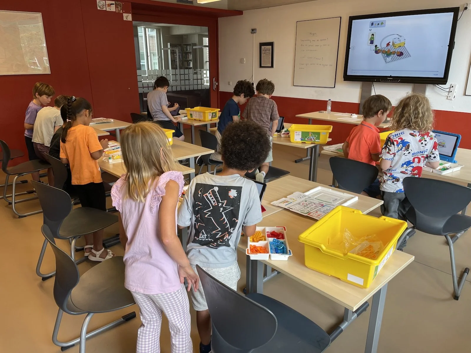 Barn i en klassrum lär sig grunderna i LEGO®-robotik och programmering genom lek. De bygger olika robotmodeller.