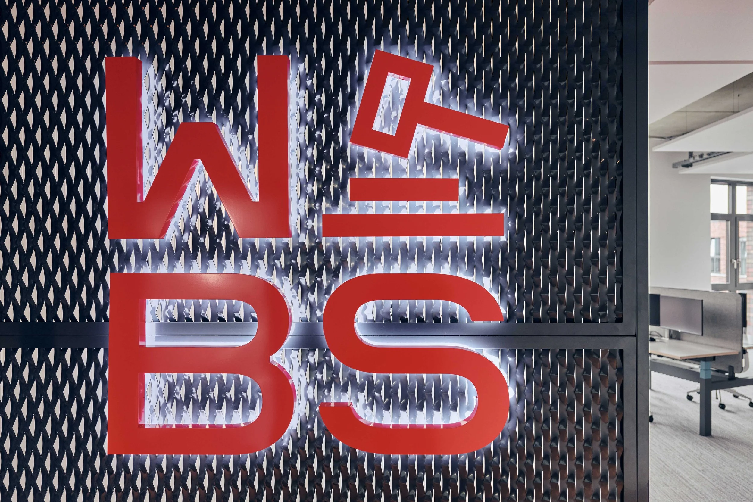 Ein modernes Wände mit großen roten Buchstaben, die das Wort 'LOVE' bilden, mit Beleuchtung im Hintergrund.