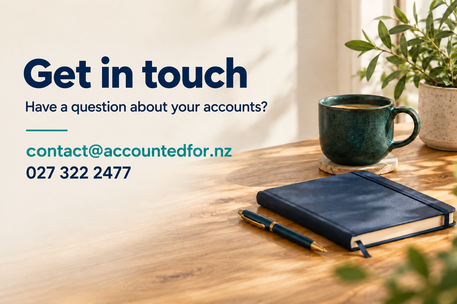 Contact information for inquiries about accounts, includes email 'contact@accountedfor.nz', phone number '027 322 2477', on a wooden desk with a green mug, closed blue notebook, beneath a pen, with potted plant in the background.