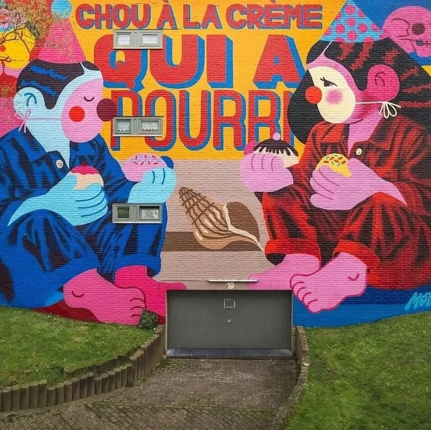 Colorful mural of two children sitting cross-legged and eating ice cream, with a large yellow and red sign that reads 'Chou à la crème qui a du cœur' in the background.