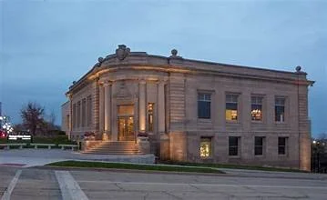 A historic stone building with classical architectural features, illuminated at dusk.