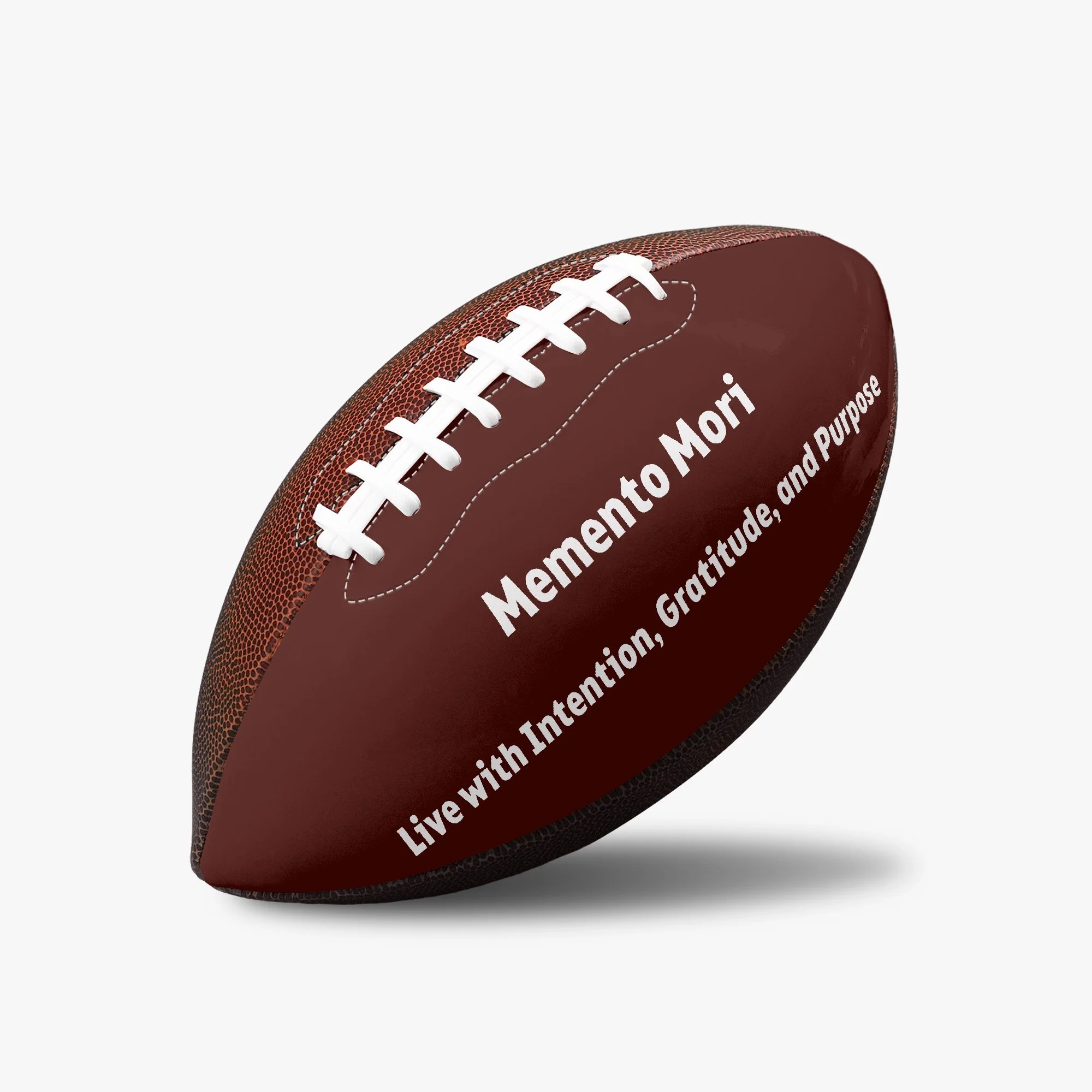Brown American football with white laces, inscribed with the words 'Memento Mori' and 'Live with intention, Gratitude, and Purpose' in white text.