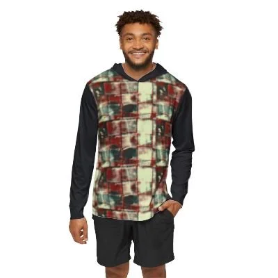 Man smiling wearing a patterned hoodie and black shorts.