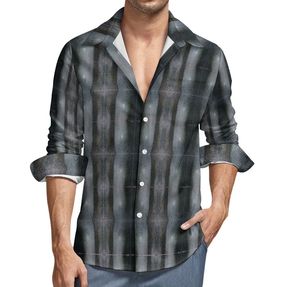 Close-up of a man wearing a dark plaid button-up shirt with rolled-up sleeves against a plain white background.